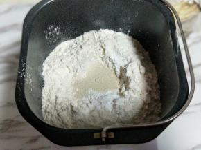 再加入高筋面粉，最后再面粉的顶端挖个小洞，(不要挖到液体) 把酵母粉倒入挖好的洞洞里。再用旁边的面粉将酵母粉盖上。