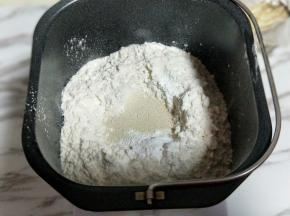 再加入高筋面粉，最后再面粉的顶端挖个小洞，(不要挖到液体) 把酵母粉倒入挖好的洞洞里。再用旁边的面粉将酵母粉盖上。