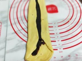 放上豆沙馅再用擀面杖将豆沙擀均匀。再将面皮的两边对折，如图。