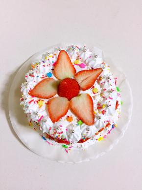 在第一片蛋糕上，抹上打发好的奶油，盖上第二片蛋糕再抹上奶油，盖上第三片蛋糕，并用奶油将蛋糕整体抹均匀。用裱花嘴在蛋糕顶部一圈挤上花纹，再在蛋糕底部边缘也挤上花纹，把切好的草莓摆在中间，蛋糕四周也均匀的贴一圈草莓片装饰一下，最后撒上适量的彩糖装饰即可。