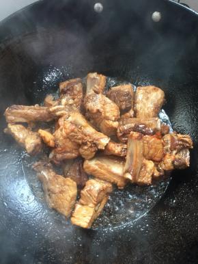 放入排骨，调中火，快速的翻炒，使每一根排骨都均匀的裹满糖色。