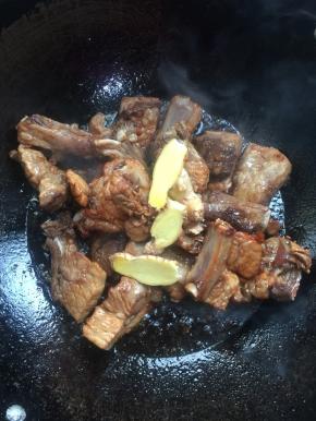 放入一勺酱油，生姜片翻炒均匀。