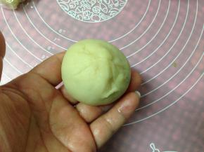 左手略压住内馅，用右手的虎口把饼皮收紧，收口朝下