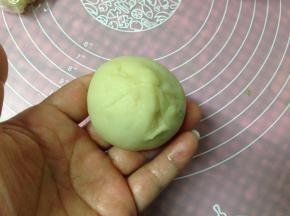 左手略压住内馅，用右手的虎口把饼皮收紧，收口朝下