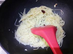 翻炒均匀，倒入一勺水，这里勺子是盛汤用的大勺子。为啥倒水呢，因为经过翻炒土豆内部的淀粉析出了，会发粘，如果是普通锅会粘锅，倒这一勺水到土豆成熟出锅正好没有汤汁而又不会发粘。汤汁收完，土豆丝正好熟，而且还保持脆的口感