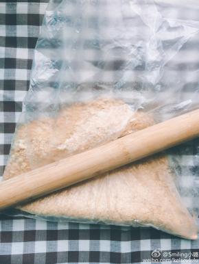 用擀面杖将饼干碾压成粉末状，当然用研磨机或料理机做出来的粉末肯定更细更快，我是偷懒，哈哈