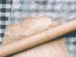 用擀面杖将饼干碾压成粉末状，当然用研磨机或料理机做出来的粉末肯定更细更快，我是偷懒，哈哈