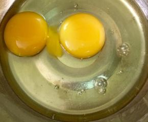 在打蛋盆里打入两个鸡蛋，鸡蛋要提前从冰箱拿出来，放至常温。