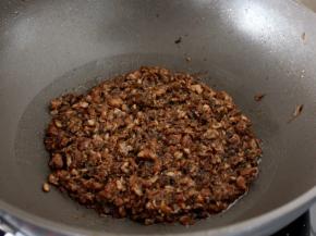 然后锅里倒少量的水烧开，将剁细的梅干菜烧肉入锅煮开几分钟，让水全部浸入菜中，这样做是为了更加入味。