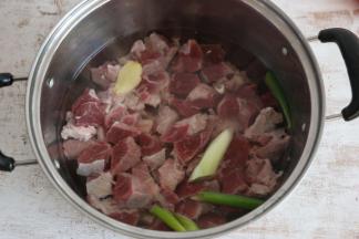 牛肉切小块后，放入锅中，加入葱段、姜片，焯烫3分钟。这一步主要是为了去除牛肉中的血水。