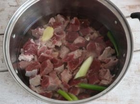 牛肉切小块后，放入锅中，加入葱段、姜片，焯烫3分钟。这一步主要是为了去除牛肉中的血水。