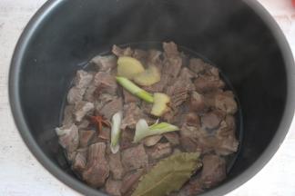 将牛肉放入电压力锅中，加入葱、姜、花椒、大料，一碗水，高压烹制30分钟。