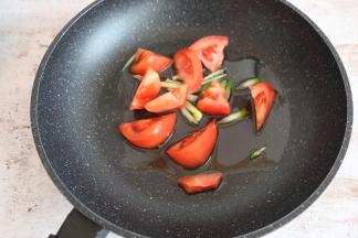 锅内倒入适量食用油，煸香葱姜后放西红柿块翻炒。