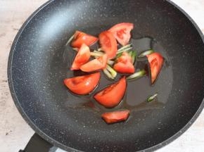 锅内倒入适量食用油，煸香葱姜后放西红柿块翻炒。