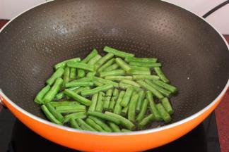 大火煸炒四季豆至皮皱皱的；