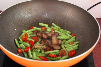 把煎好的腊肉加入翻炒；