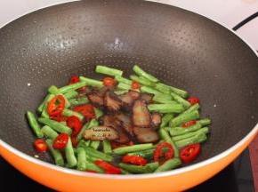 把煎好的腊肉加入翻炒；