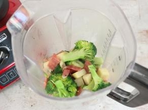 将炒熟的蔬菜倒入汉美驰破壁机的料理杯中。