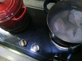 另起一个锅，放半锅水，把洗净的牛腱子放进去焯，把剩余的血沫都焯出，然后捞出牛腱子用温水清洗干净。旁边红色铸铁锅就是正在闷的香料汤。