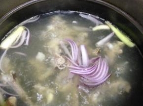先来熬鸡骨汤：鸡骨首先用冷水焯水，捞出，加入开水、葱、姜、洋葱大火煮开，小火约30分钟就可以得到鸡腿骨汤了