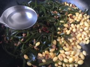 放入海带和黄豆，翻炒均匀，放入3～4汤勺的水或者高汤。