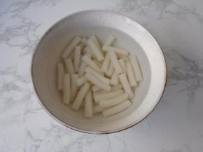 剥蛋时，我们提前将年糕放入水中略泡一会，将粘连在一起的分开，同样捞出沥水备用。