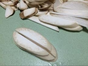 首先杏鲍菇洗净后先斜切成片，然后一开二切成宽条