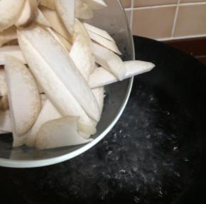 锅中加水烧开水，切好的杏鲍菇下锅焯水一边，蘑菇焯水时间长一点，5-8分钟后捞起放在盆里备用