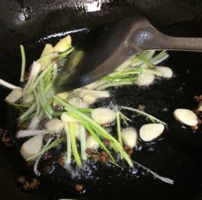 起锅热油，依次放入花椒粒、蒜片，姜、葱段爆香