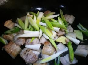 锅中少许油 下肉片煸炒出油 倒入葱姜 青蒜白