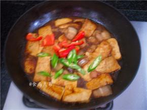 调入少许清水，大火煮1分钟，让豆腐和五花肉互相渗透，更入味，更香，然后加上辣椒、端起平底锅，抛匀食材即可装盘