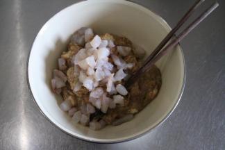 将肉馅取出，虾仁切大段加入肉馅内搅拌均匀备用；