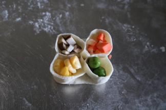 将香菇、玉米、胡萝卜、豌豆粒分别填入孔中；