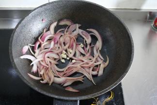 6、	洋葱炒软至透明后加入蒜末，继续翻炒；