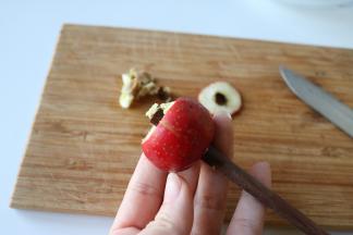 3、	用筷子粗的那头从山楂顶部穿过，推出山楂核；