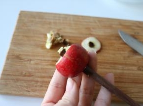 3、	用筷子粗的那头从山楂顶部穿过，推出山楂核；