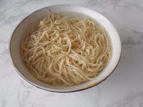 将面条捞出后，用清水冲洗至汤汁变清。