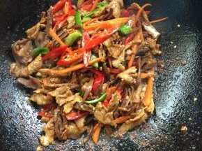 放入切好的萝卜干，红尖椒，青椒和胡萝卜条翻炒片刻。