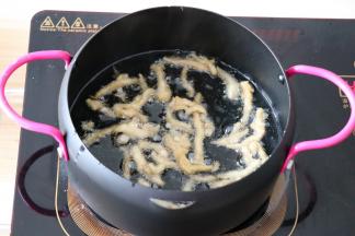 腌制好的鸡丝放入热油锅里稍微炸一下，变色即可；