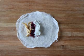 放适量鸡丝、红椰菜、萝卜丝在春卷皮上；