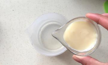 把炼乳倒入装有热水的杯子里，搅拌均匀