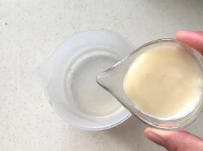 把炼乳倒入装有热水的杯子里，搅拌均匀