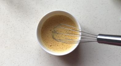 鸡蛋用手动打蛋器打散成蛋液，搅打时间久一些