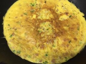 翻面，用铲子在上面压均匀一下饼，煎半分钟