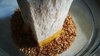 放入芝麻碗中沾满芝麻 另一头也沾下蛋液 沾满芝麻