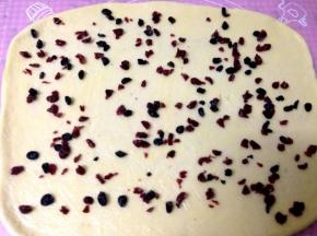 把炼乳黄油酱均匀涂抹在面皮上，在混匀撒上果干（黄油酱炼乳和果干要适量留一些装饰表面）