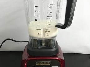 破壁机搅拌杯中倒入牛奶。