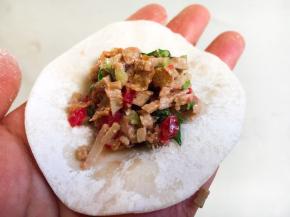 往饺子皮上放适量的饺子馅。