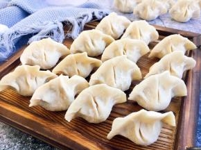 小饺子包好了，虽然没有漂亮的褶，但是很实惠，是个大肚子小饺子，薄皮大馅哦。 把包好的饺子整齐的码放在饺子板上。 饺子板上要提前均匀地撒些面粉，避免饺子和饺子板粘连。