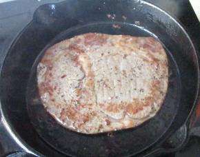 煎至一面变色，大约煎1分钟半样子，翻面煎另一面。煎到用手指压一下软硬如鼻尖的软硬程度就可以了。盘子提前再烤箱中100度预热，或者用其他方法把盘子加热，不能用凉的盘子，否则会影响牛排的口感。把牛排移入盘子中，盖上锡纸饧大约5--7分钟。这样可以让牛排的汁水被纤维充分吸收，不至于切的时候有血水。饧的过程很关键不能省略